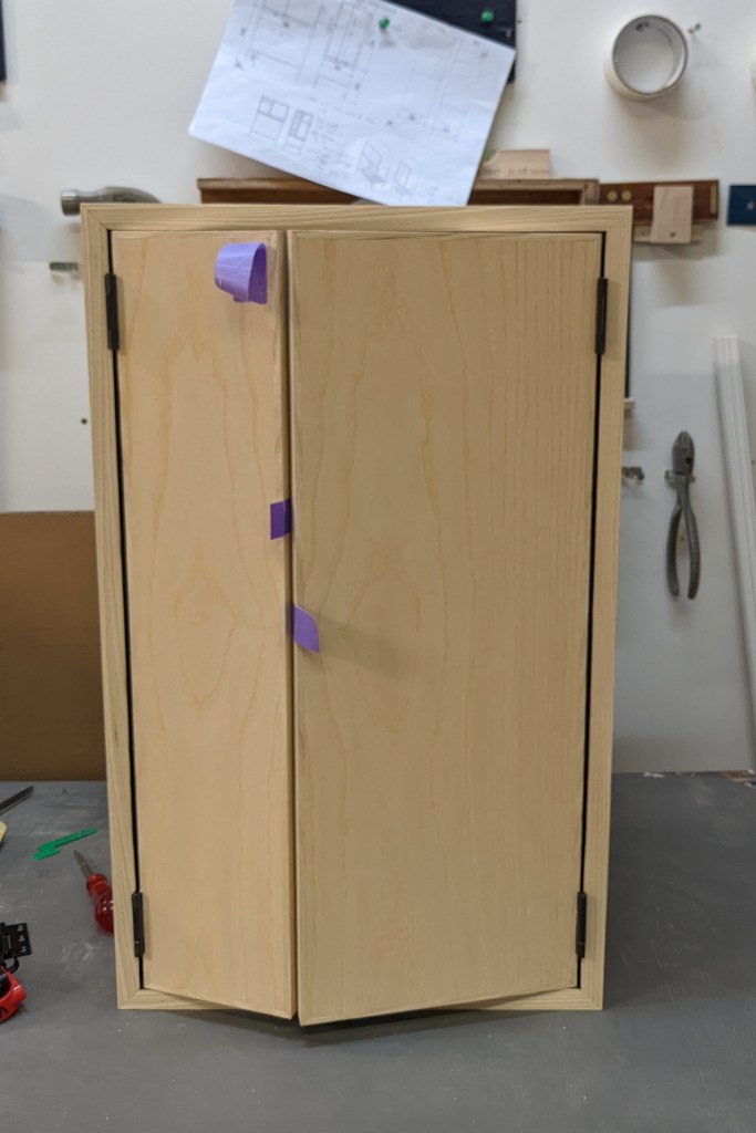 Fitting the doors, making sure that the reveals on all sides are equal and the doors swing smoothly