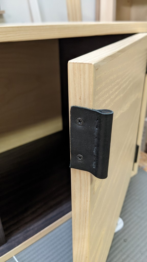 The handmade handles for the doors are made of black leather wrapped around a wooden dowel