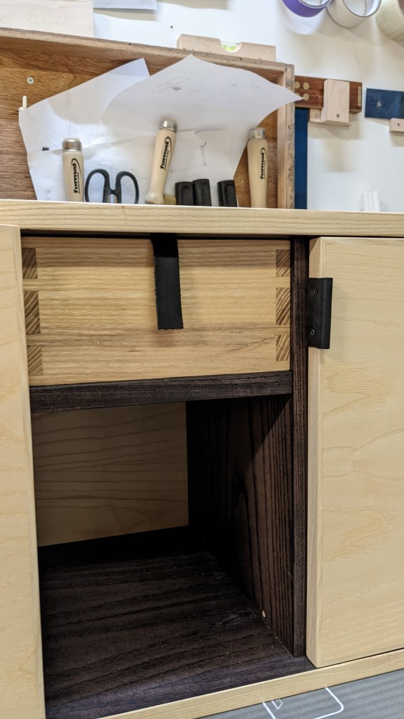 The drawer got a simple pull out of leather